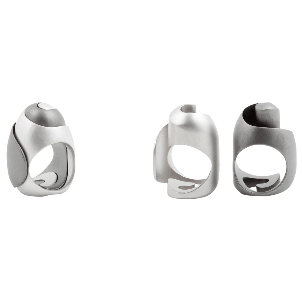 Interlocking koru rings in silver with sandblasted surfaces and rhodium plating by Sarah Herriot.