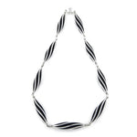 This striking neckpiece in silver showcases an inventive architectural approach to contemporary jewellery design, composed of linked twisted forms, the piece uses linear deconstruction to create visual rhythm and movement. Beat twist neck piece by Sarah Herriot.