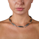 This striking neckpiece in silver showcases an inventive architectural approach to contemporary jewellery design, composed of linked twisted forms, the piece uses linear deconstruction to create visual rhythm and movement. Beat twist neck piece by Sarah Herriot.