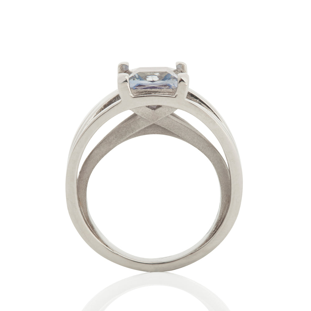 Crane ring in platinum with square grey/blue sapphire by Sarah Herriot.