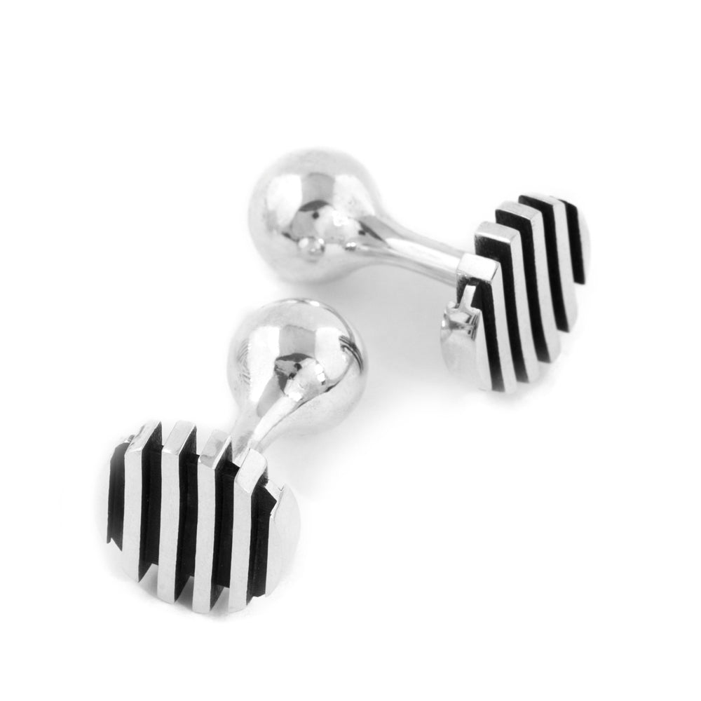 Escalator cufflinks are a clever design formed of spaced sheets of silver with a gently undulating top surface while the oxidised recesseshelp accentuate the form. An abstract form with linear deconstruction. Escalator cufflinks by Sarah Herriot.
