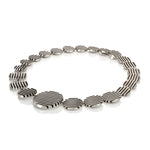 The escalator neckpiece shows geometric abstraction through its precisely offset tapering disc construction, the gently undulating surfaces create a dynamic interplay of light, while the oxidised recesses articulate the linear deconstructed form. Escalator neckpiece by Sarah Herriot.