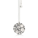 Galaxy pendant is an elegant construction using circle motif in sterling silver. Sarah's imagining of the night sky, packed full of stars, as it was in her childhood in new zealand. Her design runs through both sides of the surface, one side convex, the other concave. Galaxy pendant by Sarah Herriot.