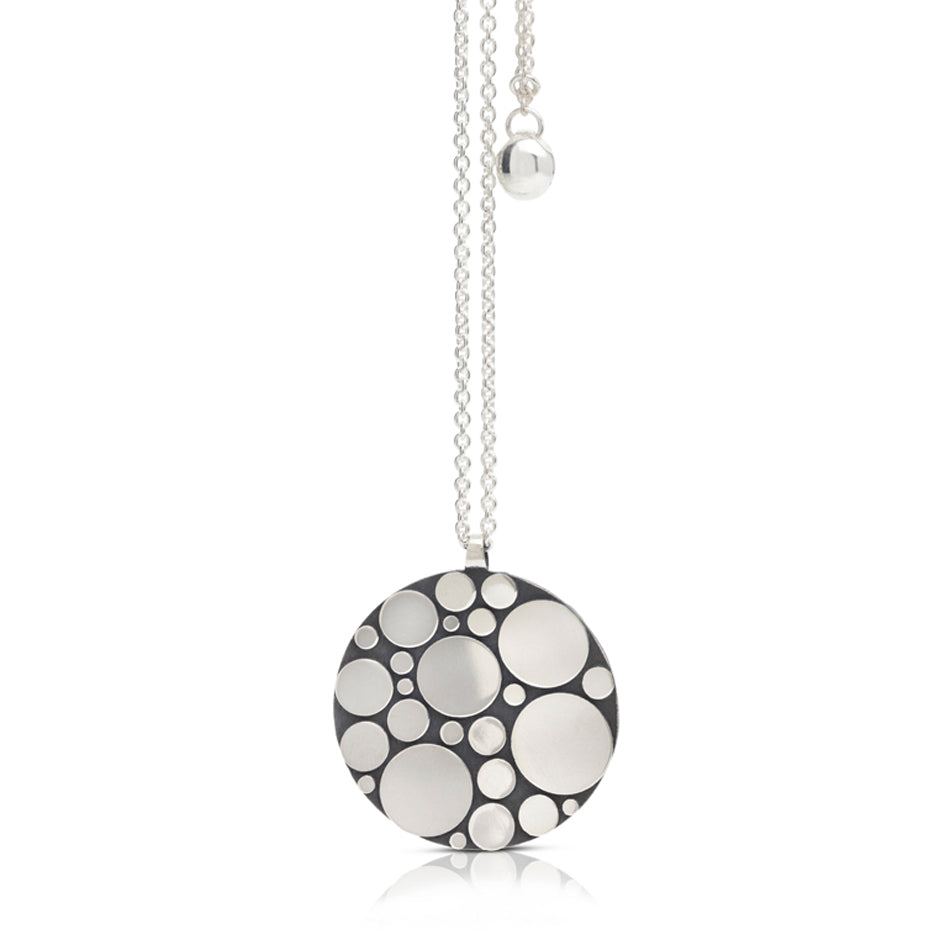 Galaxy pendant is an elegant construction using circle motif in sterling silver. Sarah's imagining of the night sky, packed full of stars, as it was in her childhood in new zealand. Her design runs through both sides of the surface, one side convex, the other concave. Galaxy pendant by Sarah Herriot.