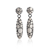 Galaxy drop earrings are an elegant construction using a circle motif on front and back of the piece, in oxidised silver.  Galaxy drop earrings by Sarah Herriot.