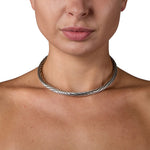 A solid silver torque featuring an abstract rhythmic linear pattern dancing across the surface, the ultimate in understated elegance, with a seamless tension clasp. This timeless piece combines technical precision with minimalist design, offering effortless wearability without compromising on craftsmanship. Jazz tension torque by Sarah Herriot.
