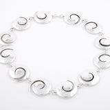 Koru neckpiece in silver with oxidised recesses by Sarah Herriot.