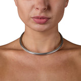 A solid silver torque featuring an slowly turning linear pattern rolling across the surface, the ultimate in understated elegance, with a seamless tension clasp. This timeless piece combines technical precision with minimalist design, offering effortless wearability without compromising on craftsmanship. Lazy torque by Sarah Herriot.