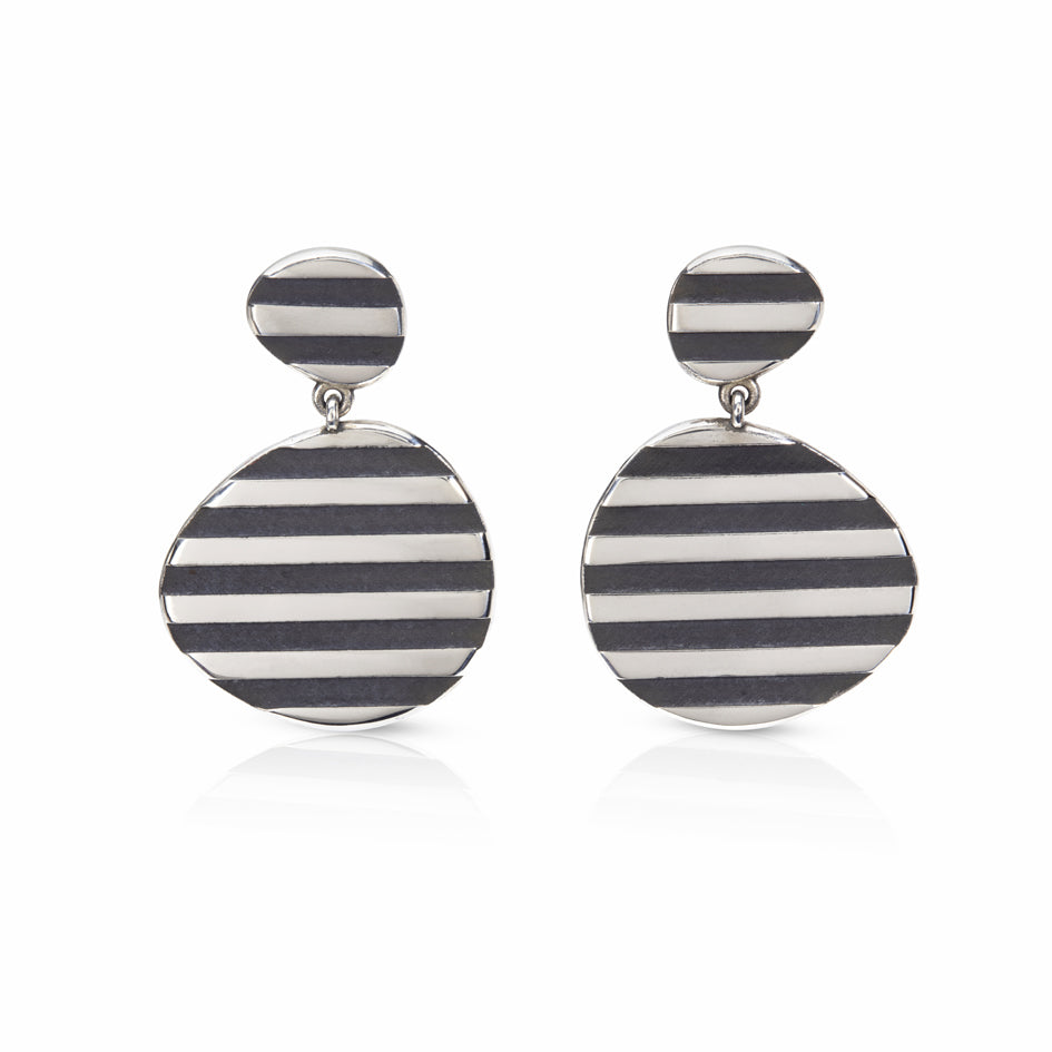 These silver op earrings really pop when worn, eye catching and lots of fun. They frame that face beautifully and will hang differently when swapped around.Op earrings by Sarah Herriot.