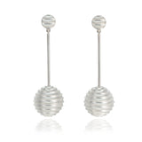 Lunar earrings, studs fitting with an elegant long drop finished with a hollow sphere formed of an undulating texture in brushed silver.  Lunar earrings by Sarah Herriot.