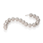 This striking neckpiece features hollow silver spheres inspired by planetary forms, creating an architectural statement piece with surprising lightness. The sculptural design balances bold visual impact with wearable comfort. Each sphere is meticulously crafted to catch light beautifully, adding dimension to any ensemble. A playful yet sophisticated addition to any collection, this piece celebrates celestial beauty through contemporary design. Lunar neckpiece by Sarah Herriot.