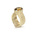 Lunar ring with undulating textured 18ct gold and set with a colour changing tourmaline showing amber gold and green. The design is based on the throwing of a ceramic pot, with the finger indentations up the walls, giving an almost planetary feel.  Lunar ring by Sarah Herriot.