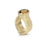 Lunar ring with undulating textured 18ct gold and set with a colour changing tourmaline showing amber gold and green. The design is based on the throwing of a ceramic pot, with the finger indentations up the walls, giving an almost planetary feel.  Lunar ring by Sarah Herriot.
