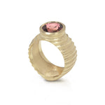 Lunar ring with undulating textured 18ct gold and set with an elegant soft rose coloured tourmaline. The design is based on the throwing of a ceramic pot, with the finger indentations up the walls, giving an almost planetary feel. Lunar ring by Sarah Herriot.