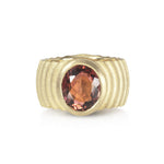 Lunar ring with undulating textured 18ct gold and set with an elegant soft rose coloured tourmaline. The design is based on the throwing of a ceramic pot, with the finger indentations up the walls, giving an almost planetary feel. Lunar ring by Sarah Herriot.