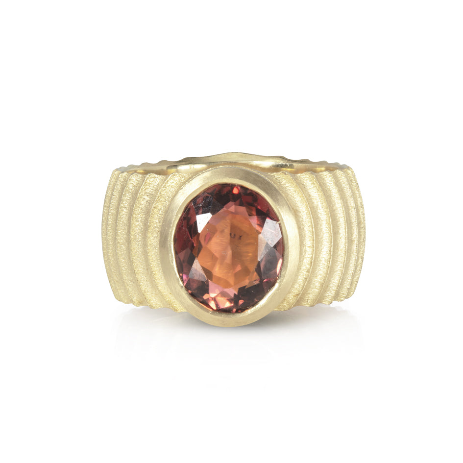 Lunar ring with undulating textured 18ct gold and set with an elegant soft rose coloured tourmaline. The design is based on the throwing of a ceramic pot, with the finger indentations up the walls, giving an almost planetary feel. Lunar ring by Sarah Herriot.