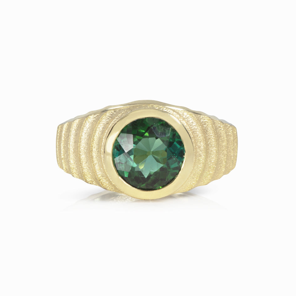 Lunar ring with undulating textured 18ct gold and set with a vibrant green tourmaline. The design is based on the throwing of a ceramic pot, with the finger indentations up the walls, giving an almost planetary feel. Lunar ring by Sarah Herriot.