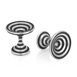 These striking silver cufflinks feature a mesmerising design with concentric black lines spiralling into vortexes at both ends, creating an optical illusion of depth and movement. Op #1 cufflinks by Sarah Herriot.