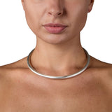 A solid silver torque featuring a seamless tension clasp, the ultimate in understated elegance. This timeless piece combines technical precision with minimalist design, offering effortless wearability without compromising on craftsmanshipTension neck torque by Sarah Herriot.