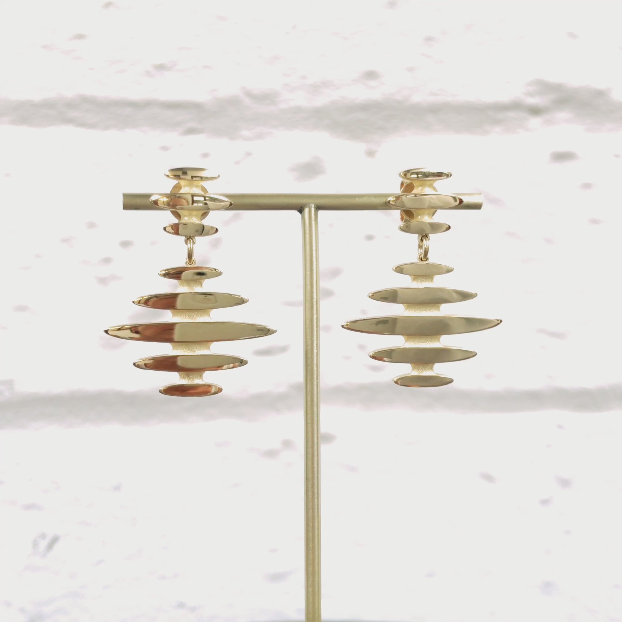 Mirage drop earrings, a stud and drop of flickering light in 18ct gold.  The mirage design is based the flickering line of light seen across the ocean waves as the sun sets.  Mirage earrings by Sarah Herriot.