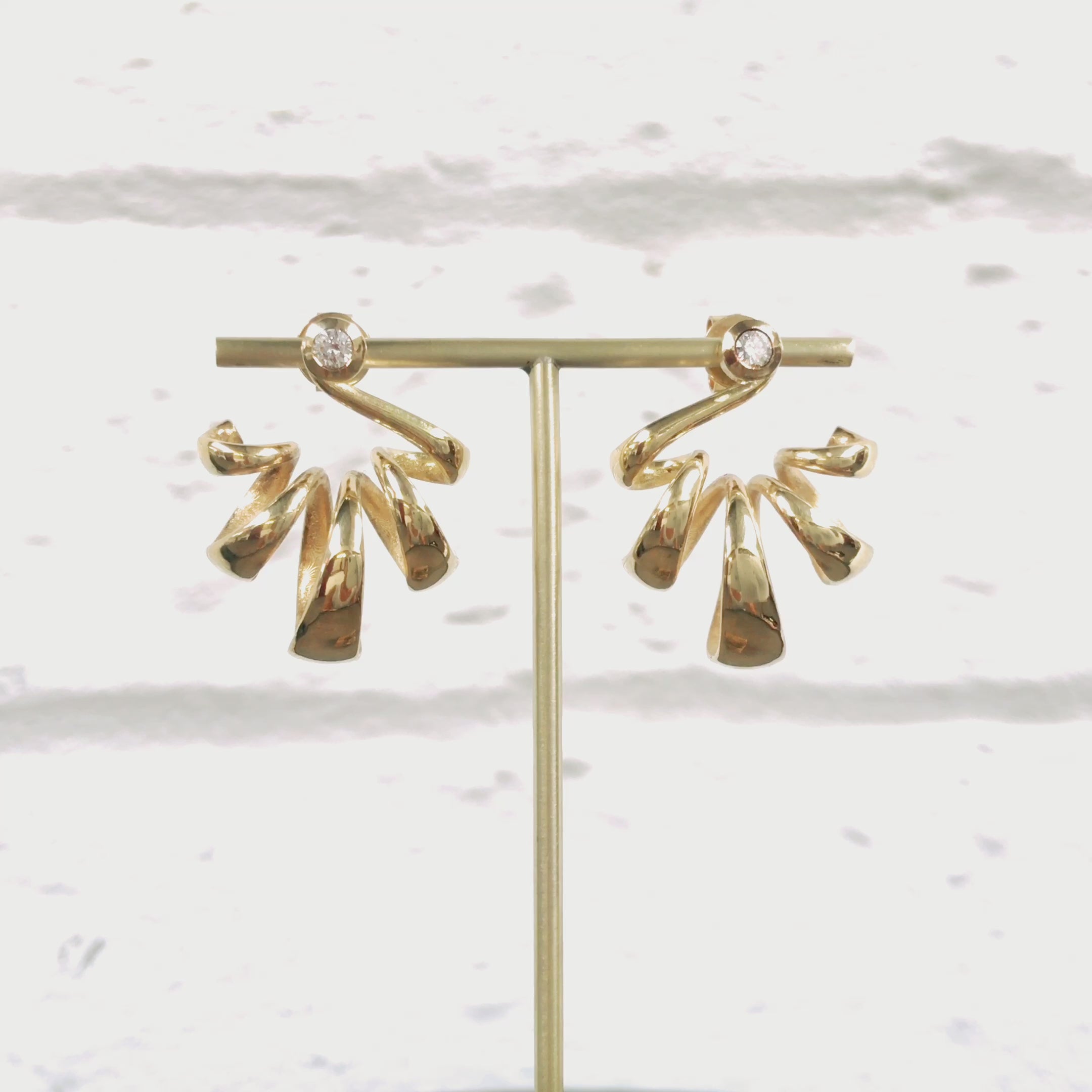 Acrobat earring are flowing loops of tapering 18ct gold tipped with a bright white diamond at the ear.  These earrings frame the ear beautifully, the loops making wonderful sculptural shapes. Acrobat earrings by Sarah Herriot.