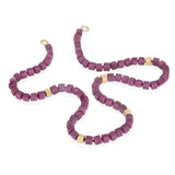 This necklace features elegant ruby and 18ct gold cubes with refined sophistication, creating a striking yet understated jewel. A masterwork of minimalist luxury that celebrates the natural beauty of ruby's opaque raspberry colour in combination with rich gold. through timeless architectural form. Ruby cube necklace by Sarah Herriot.