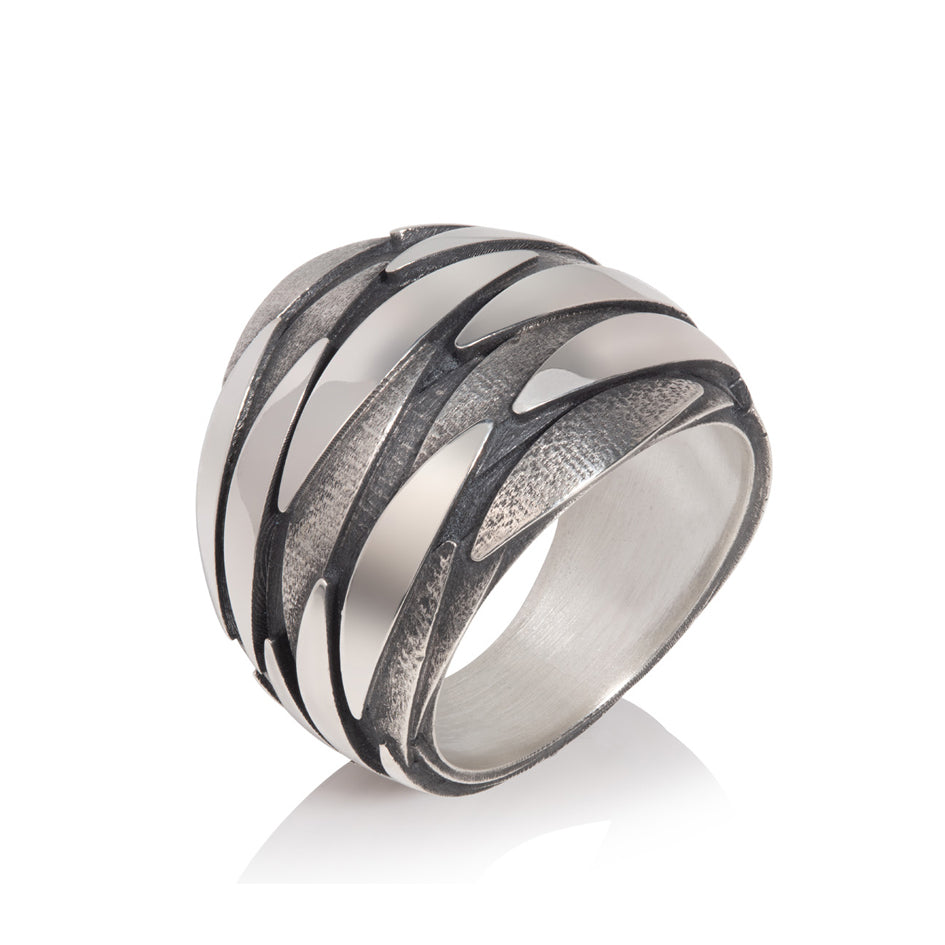 Shoal ring is constructed of three layers of silver fish revolving round the surface, oxidisation accentuates and defines the movement. Shoal ring by Sarah Herriot.