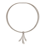 Splash neckpiece in polished and sandblasted silver with rhodium plating on a nine strand steel neck wire by Sarah Herriot.