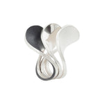 A set of three silver spooning rings create a theatrical and dynamic form for the finger, combining three different finishes to accentuate the sculptural nature of the piece.  Spooning rings by Sarah Herriot.