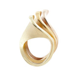 A set of three silver spooning rings create a theatrical and dynamic form for the finger, combining three different colours of gold plate to accentuate the sculptural nature of the piece, green yellow and rose. Spooning rings by Sarah Herriot.