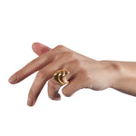 A set of three silver spooning rings create a theatrical and dynamic form for the finger, combining three different colours of gold plate to accentuate the sculptural nature of the piece, green yellow and rose. Spooning rings by Sarah Herriot.