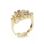 Staffa ring formed of undulating columns of 18ct gold and a scattering of seven vibrant blue Sri Lankan sapphires. The design is inspired by fingal's cave on the isle of staffa off the west coast of Scotland. Textured surfaces echo the natural basalt rock formations. Staffa reing by Sarah Herriot.