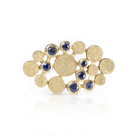 Staffa ring formed of undulating columns of 18ct gold and a scattering of seven vibrant blue Sri Lankan sapphires. The design is inspired by fingal's cave on the isle of staffa off the west coast of Scotland. Textured surfaces echo the natural basalt rock formations. Staffa reing by Sarah Herriot.
