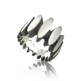 Stepping stone ring in silver is a path of silver steps around the finger, with oxidised recesses to accentuate the sculptural nature of the piece. Stepping stone ring by Sarah Herriot.