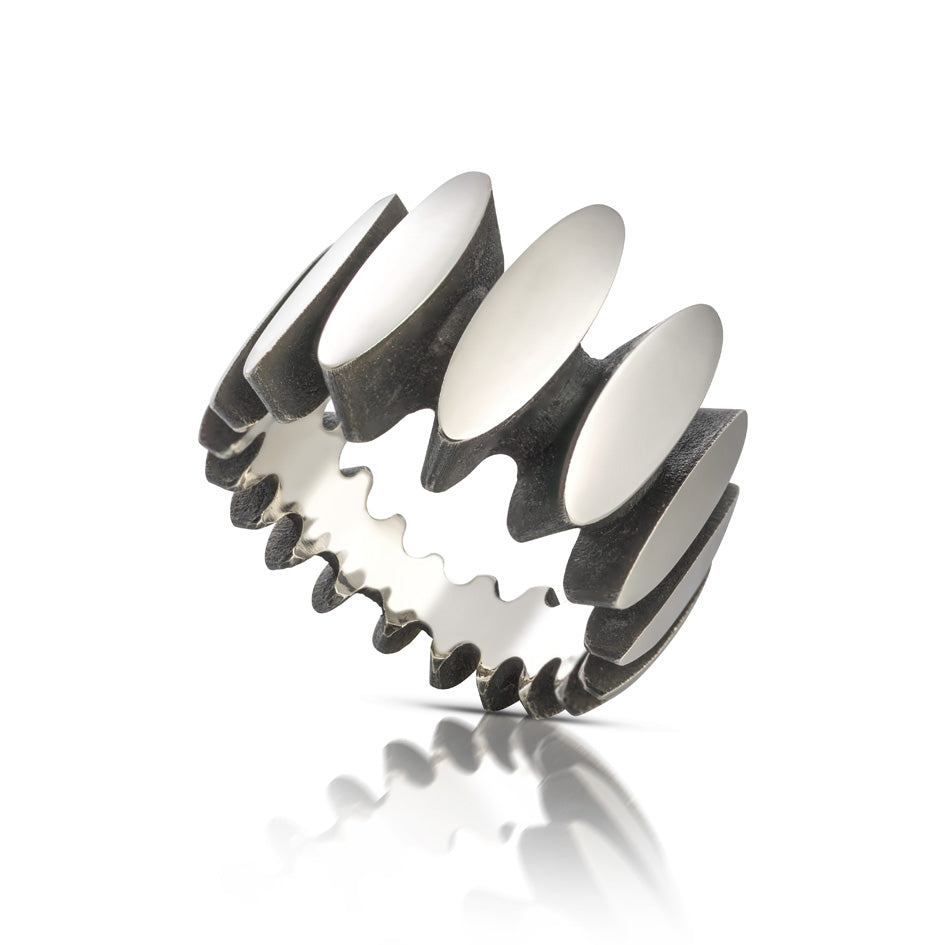Stepping stone ring in silver is a path of silver steps around the finger, with oxidised recesses to accentuate the sculptural nature of the piece. Stepping stone ring by Sarah Herriot.
