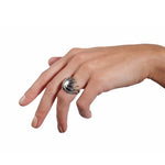 Sun ring is a wonderfully architecturally formed ring in silver, flowing twisted sheets with oxidised recesses to accentuate the sculptural nature of the piece. Sun ring by Sarah Herriot.