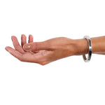 A masterfully engineered solid silver bangle with a seamless tension clasp that requires no visible mechanism. The square-section wire creates a refined, sculptural form that sits beautifully on the wrist with an authentic weight and presence. Seamless design embodies minimalist principles, pure form without ornamentation.  Tension bangle by Sarah Herriot.